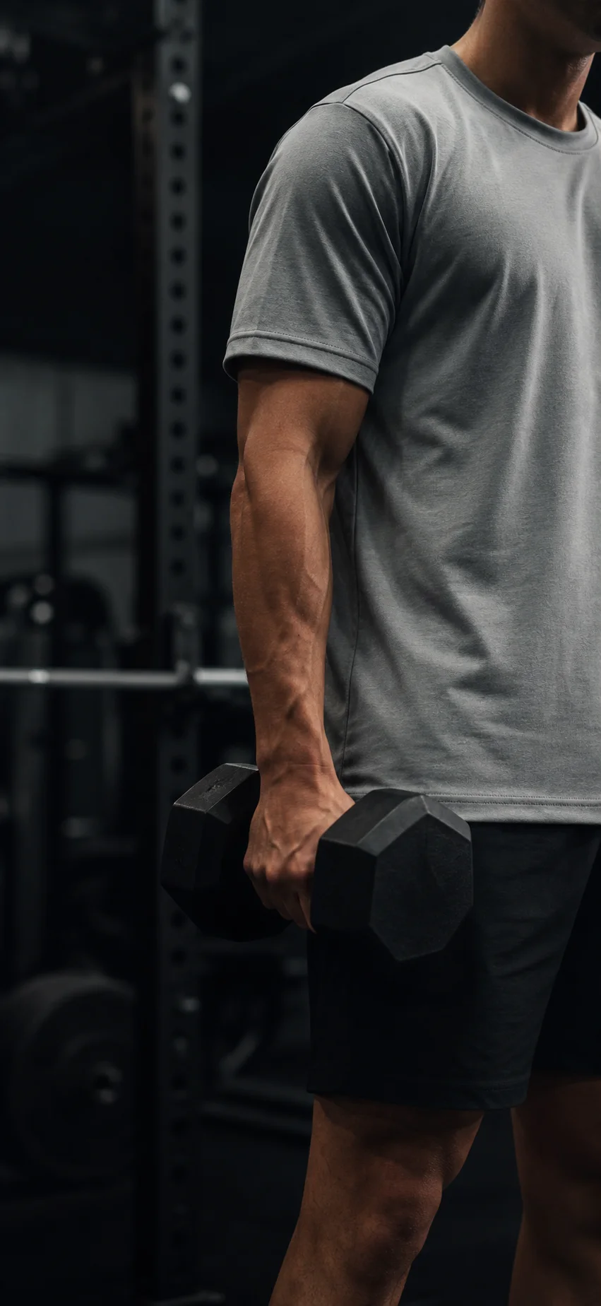 Persona entrenando con mancuerna usando remera Irruptivo en gimnasio